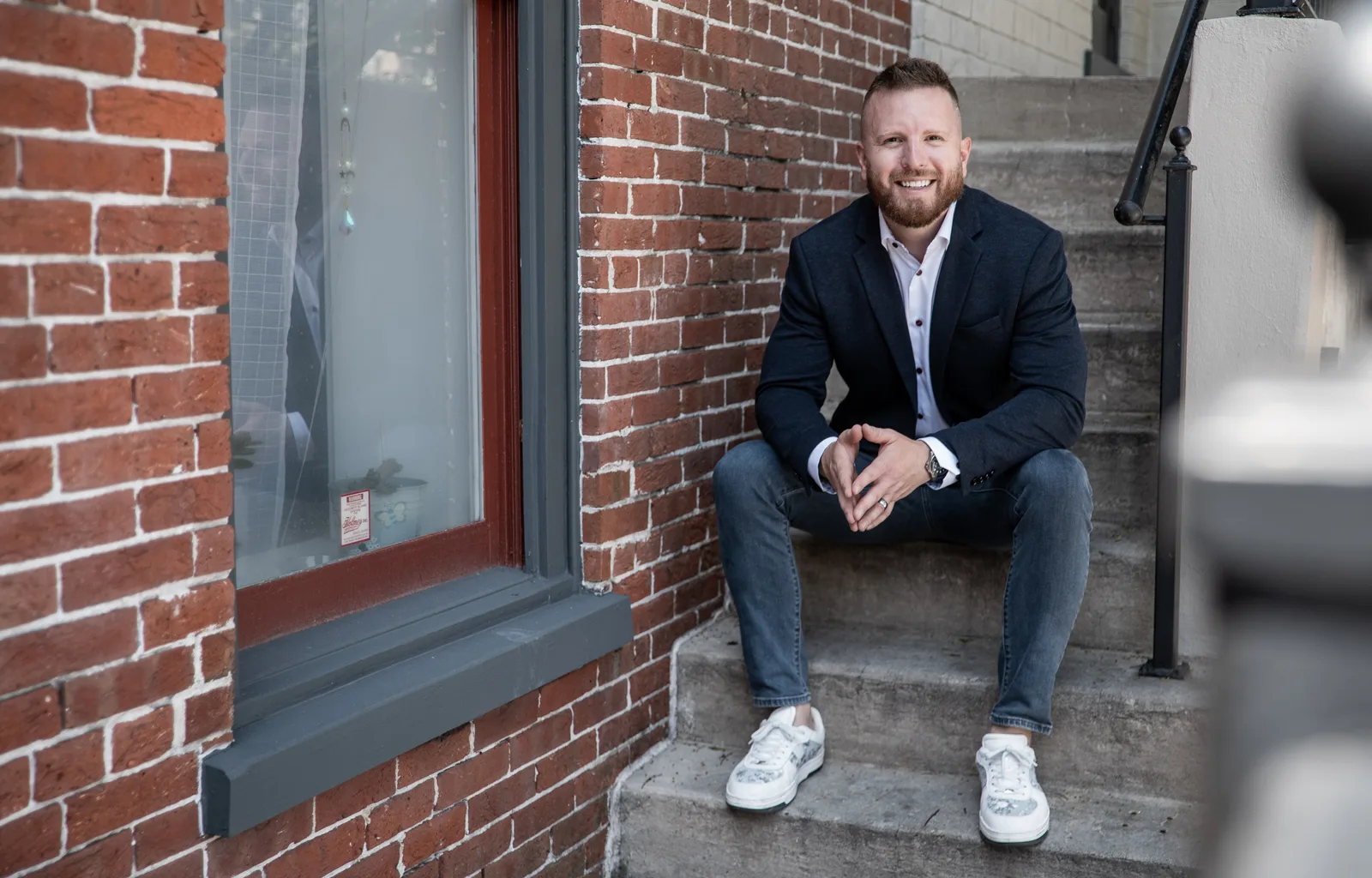 Austin Houser seated on brick steps, smiling